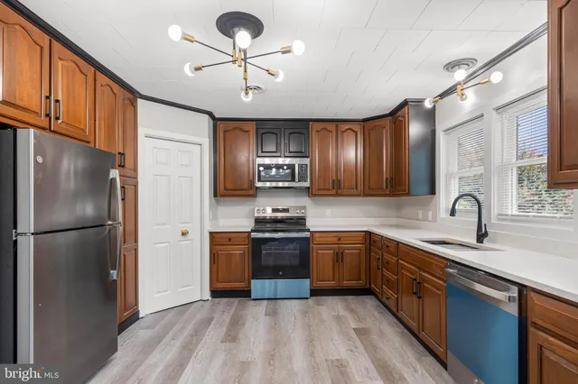 a kitchen with stainless steel appliances granite countertop refrigerator a sink cabinets and wooden floor