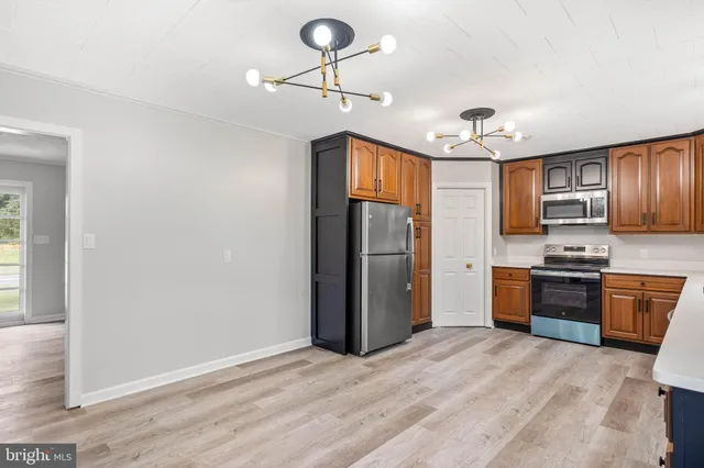 a kitchen with stainless steel appliances granite countertop a refrigerator a stove top oven a sink and dishwasher