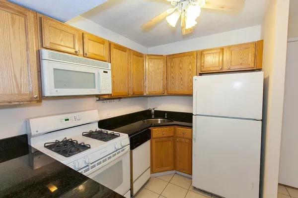 a kitchen with a refrigerator a stove top oven a sink and cabinets