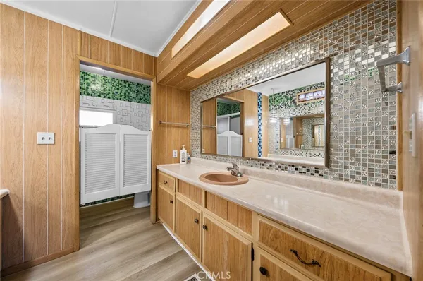 a bathroom with a granite countertop sink and a large mirror