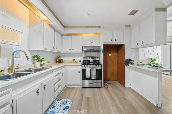 a kitchen with a sink cabinets stainless steel appliances and a window