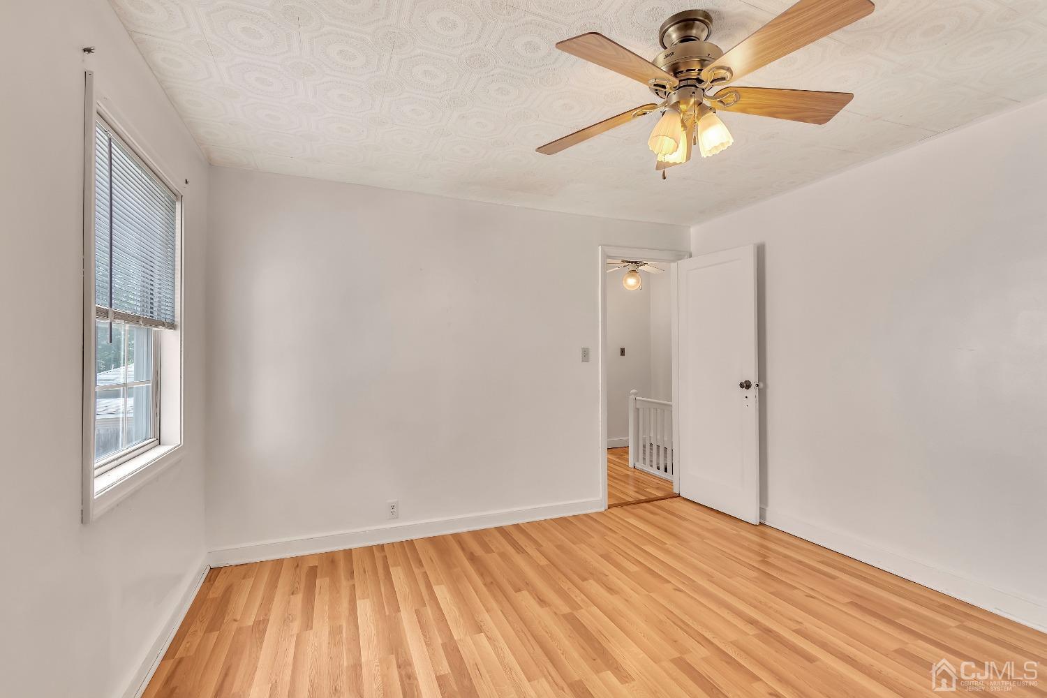 42 MacArthur Drive Edison, NJ 08837 - Photo 18 of 25 a view of empty room with wooden floor and fan