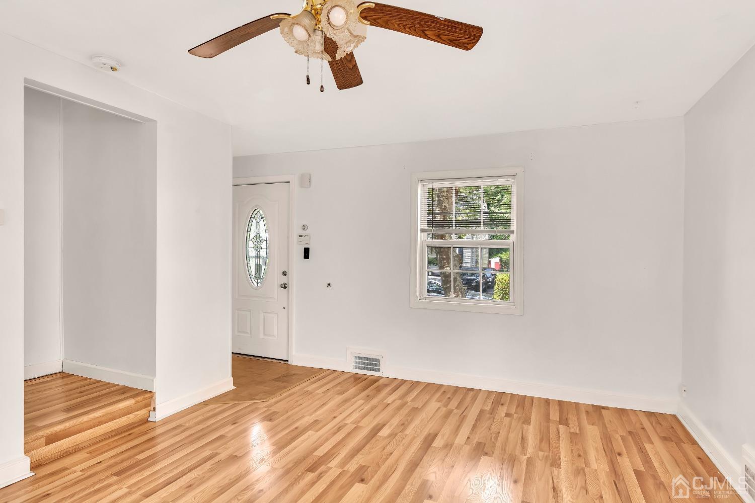 42 MacArthur Drive Edison, NJ 08837 - Photo 5 of 25 a view of empty room with wooden floor and fan