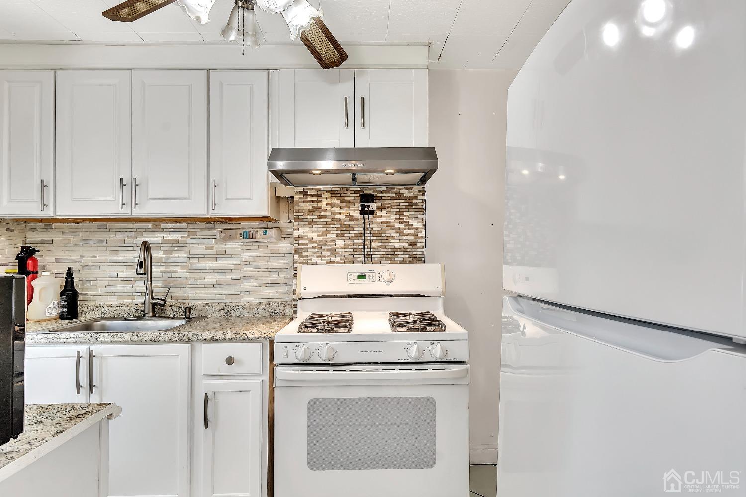 42 MacArthur Drive Edison, NJ 08837 - Photo 9 of 25 a kitchen with stainless steel appliances granite countertop a stove and a white cabinets