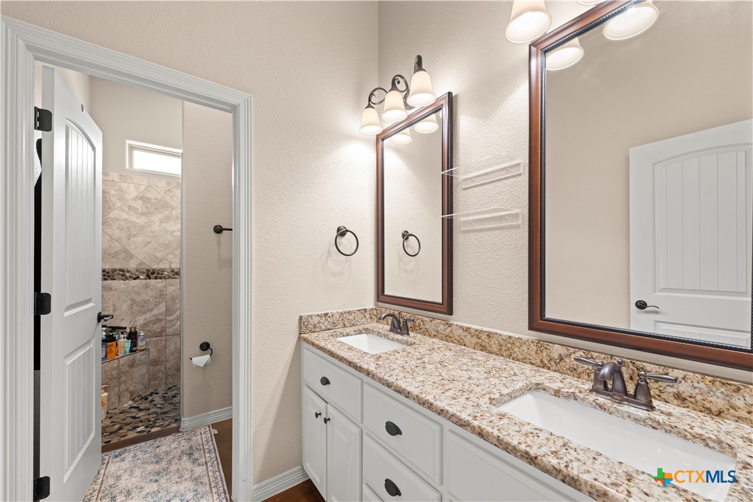2649 Bowles Ranch Road Belton, TX 76513 - Photo 24 of 36 a bathroom with a granite countertop sink and a mirror