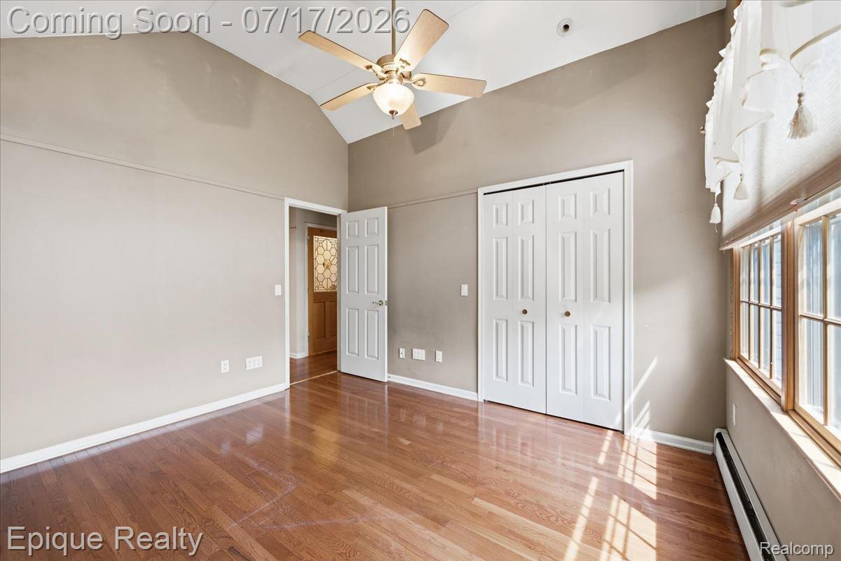 22520 Waltz Road New Boston, MI 48164 - Photo 32 of 43 Vaulted ceiling with a ceiling fan light fixture, wood-finish flooring, and white bi-fold closet doors