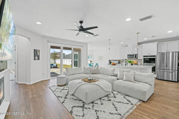 a living room with furniture and a view of kitchen