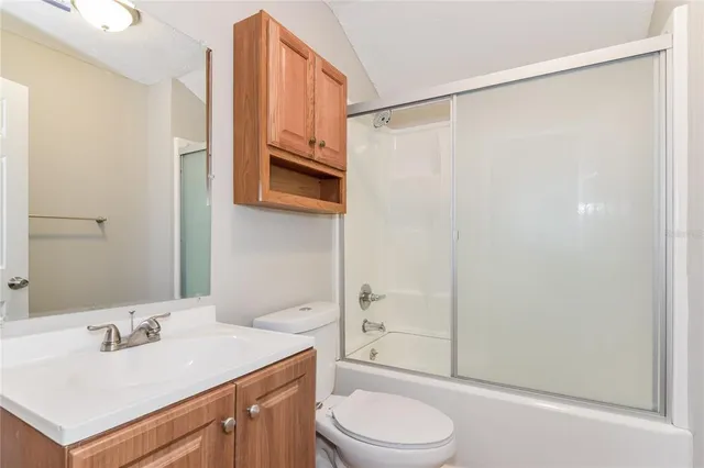 a view of a house with a yard and a large tree