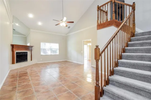 a view of staircase with white walls and fireplace