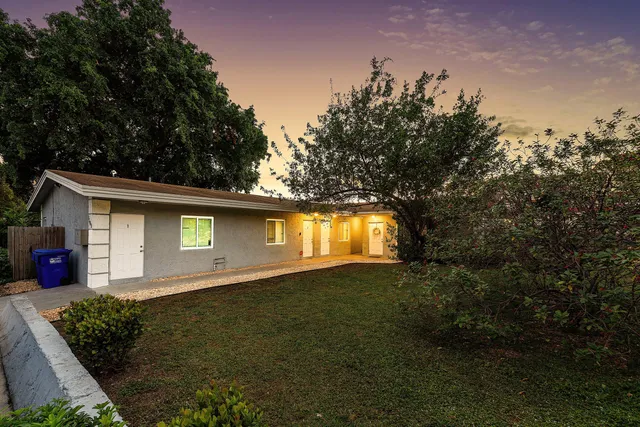 a backyard of a house with garage and plants