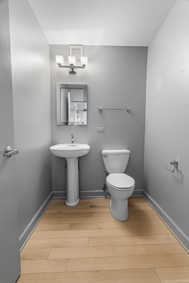 21 West Chestnut Street, Unit 1403 Chicago, IL 60654 - Photo 16 of 19 a bathroom with a toilet a sink and mirror
