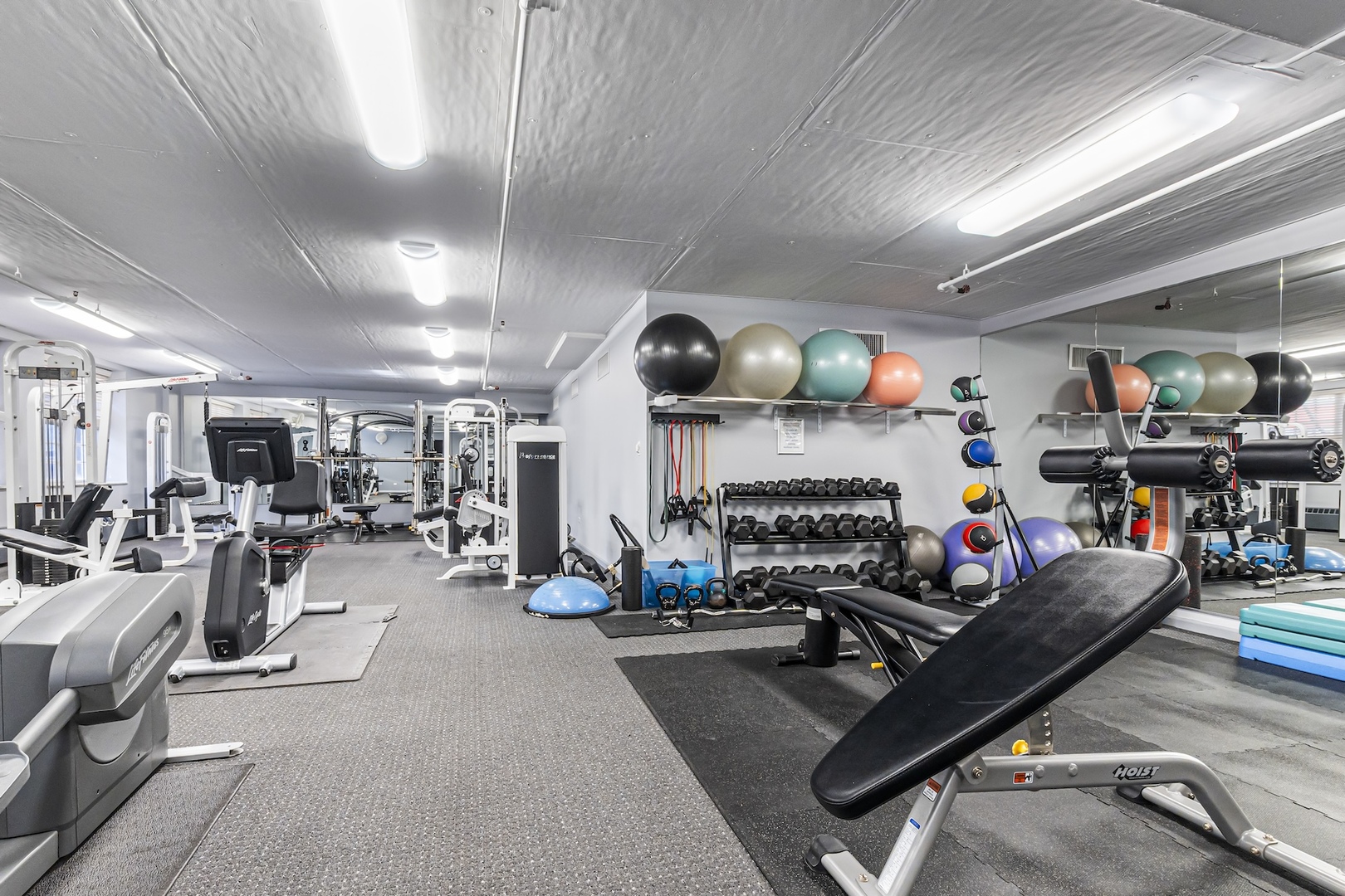 21 West Chestnut Street, Unit 1403 Chicago, IL 60654 - Photo 19 of 19 a living room with furniture gym equipment and a fireplace