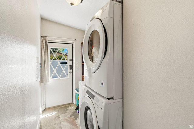 327 North Lodge Road Central, UT 84722 - Photo 12 of 45 Laundry area featuring a stacked washer and dryer, tile flooring, and a door with diamond-patterned glass panes