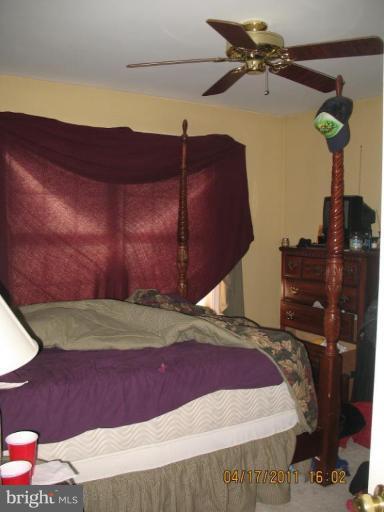4721 East Basford Road Frederick, MD 21703 - Photo 19 of 28 a bed sitting in a bedroom next to a lamp