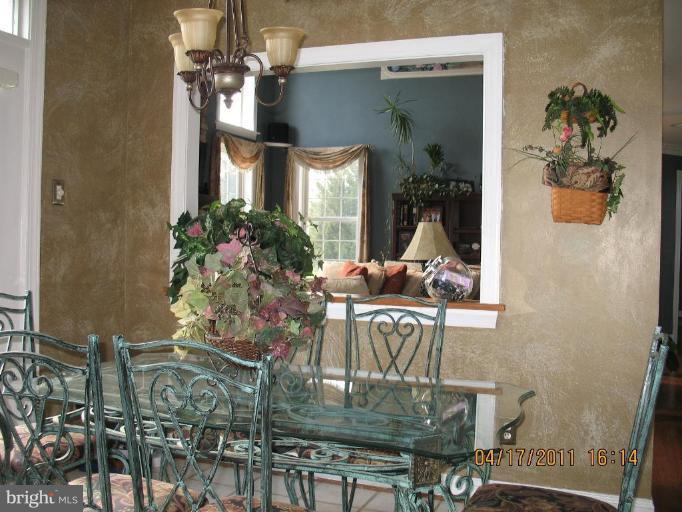 4721 East Basford Road Frederick, MD 21703 - Photo 20 of 28 a dining room with furniture a potted plant and a chandelier