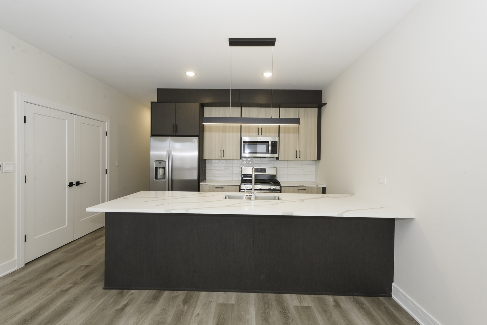 3762 South Indiana Avenue Chicago, IL 60653 - Photo 22 of 27 a large white kitchen with a sink a window and cabinets