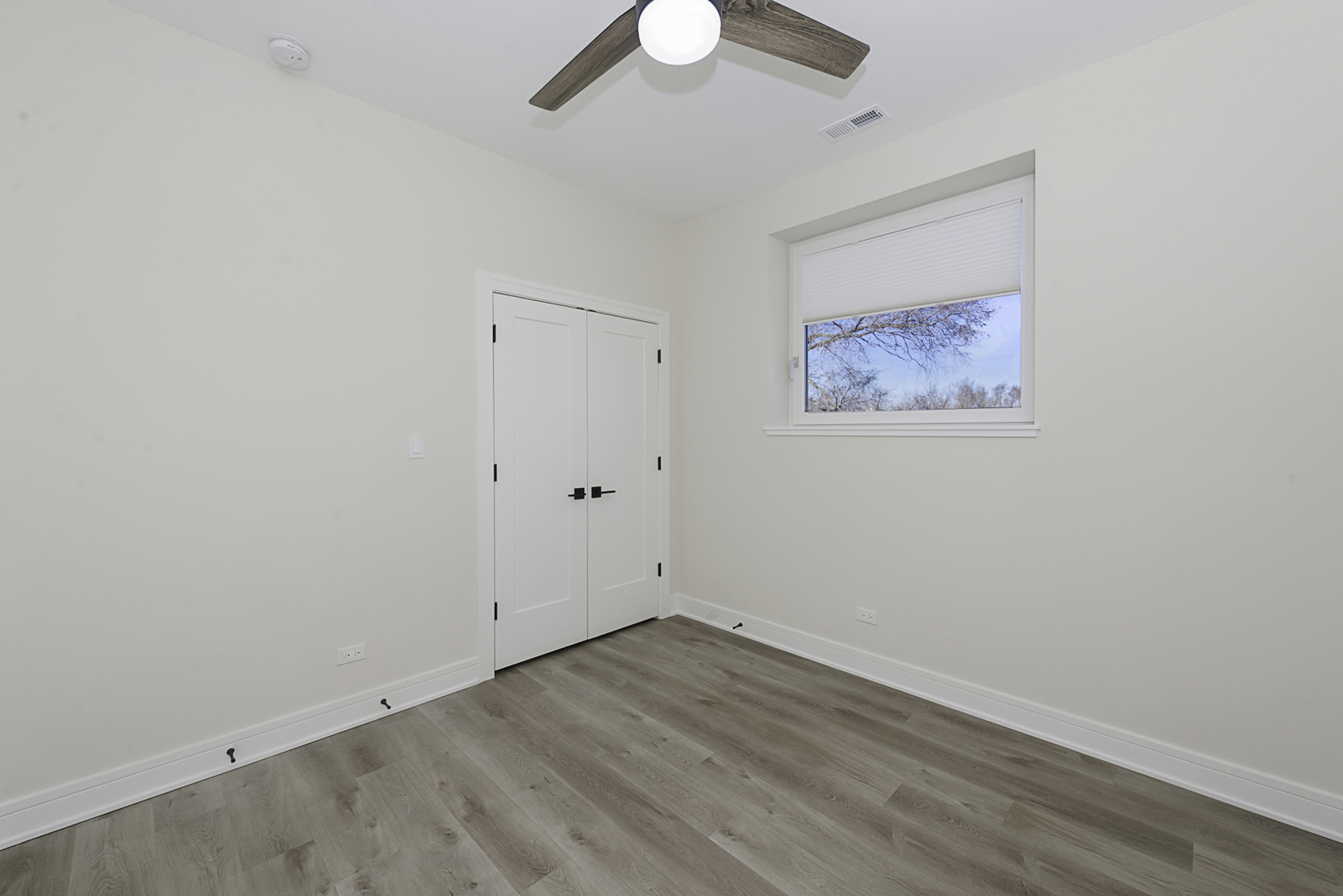 3762 South Indiana Avenue Chicago, IL 60653 - Photo 25 of 27 an empty room with a ceiling fan and wooden floor