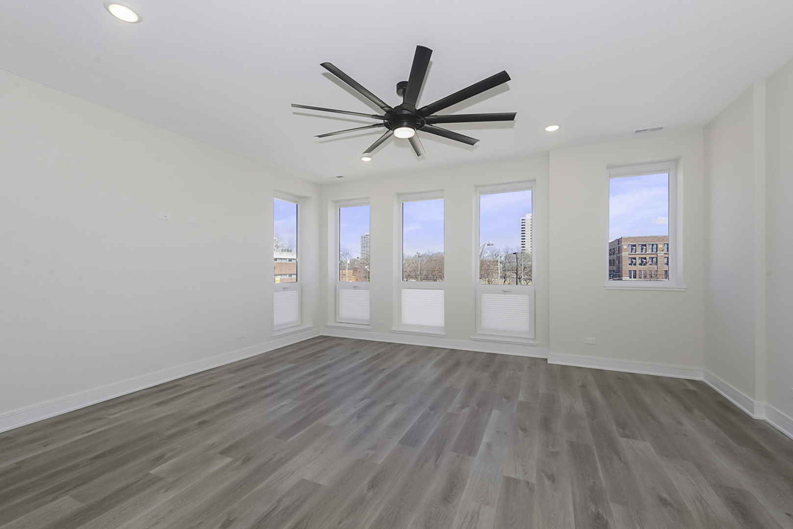 3762 South Indiana Avenue Chicago, IL 60653 - Photo 3 of 27 an empty room with wooden floor ceiling fan and windows