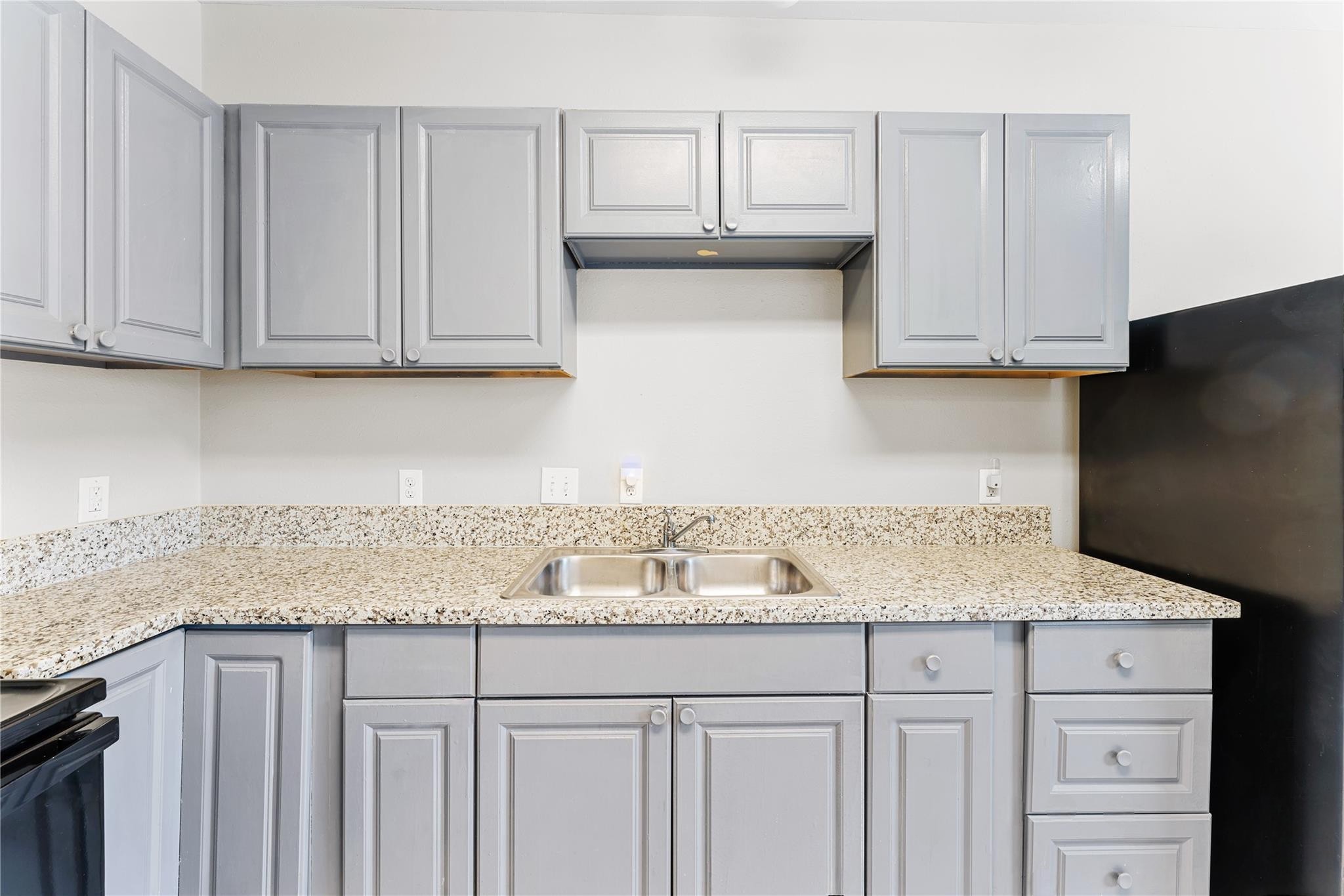9610 Buffum Street, Unit B Houston, TX 77051 - Photo 7 of 25 a kitchen with granite countertop white cabinets and a sink
