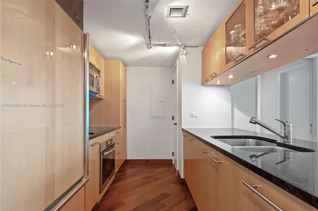 a kitchen with granite countertop a sink and cabinets