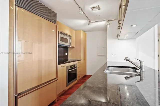 a kitchen with stainless steel appliances a refrigerator and a stove