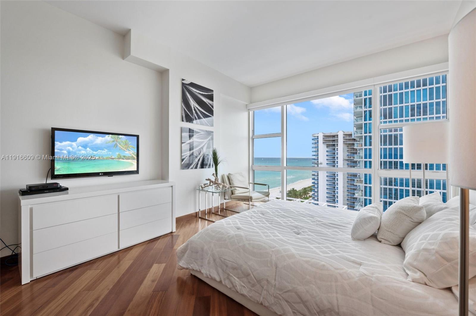 6801 Collins Avenue, Unit PH6 10) Miami Beach, FL 33141 - Photo 16 of 48 a bedroom with a bed and a flat screen tv