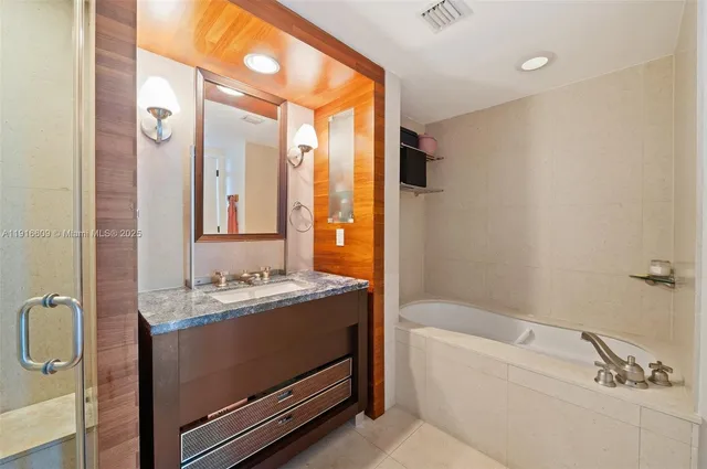 a bathroom with a tub sink and mirror