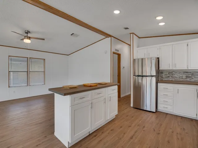 a view of kitchen with microwave and refrigerator