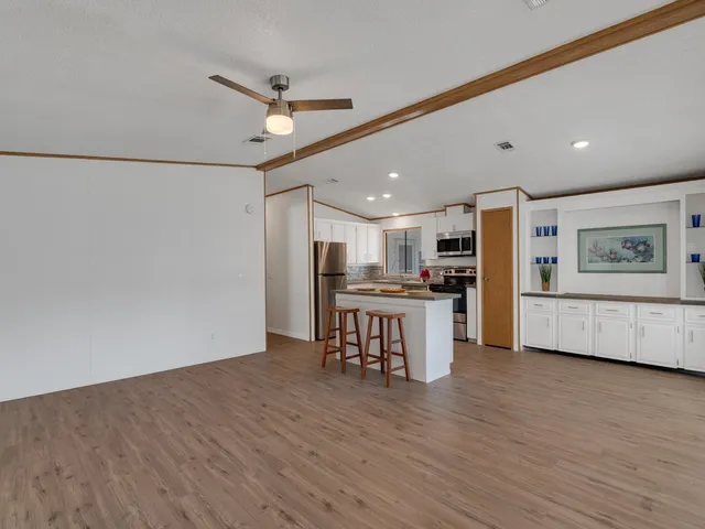 a kitchen with kitchen island wooden cabinets and stainless steel appliances
