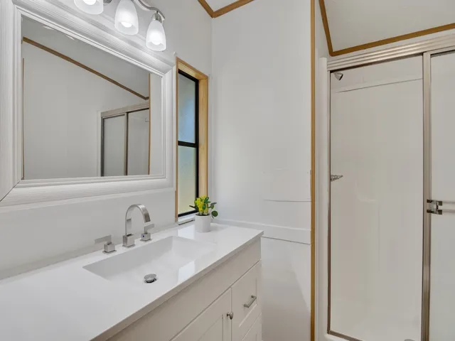 an empty room with wooden floor chandelier fan and windows