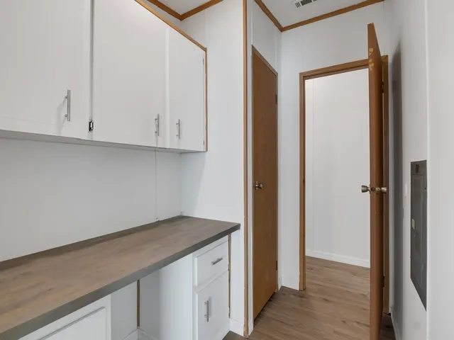 a kitchen with white cabinets and stainless steel appliances