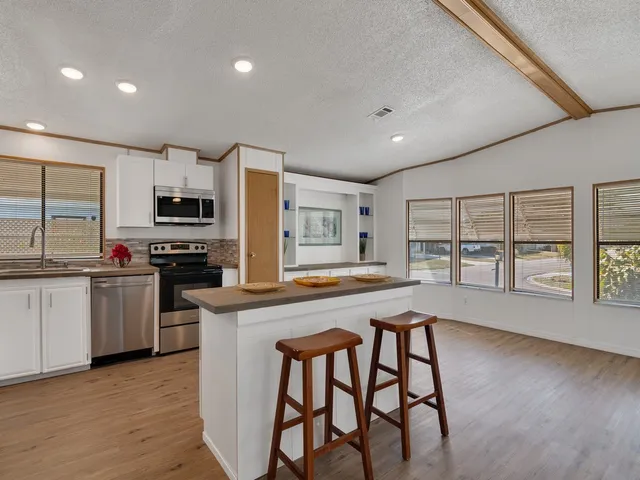 a view of kitchen with microwave a stove and furniture