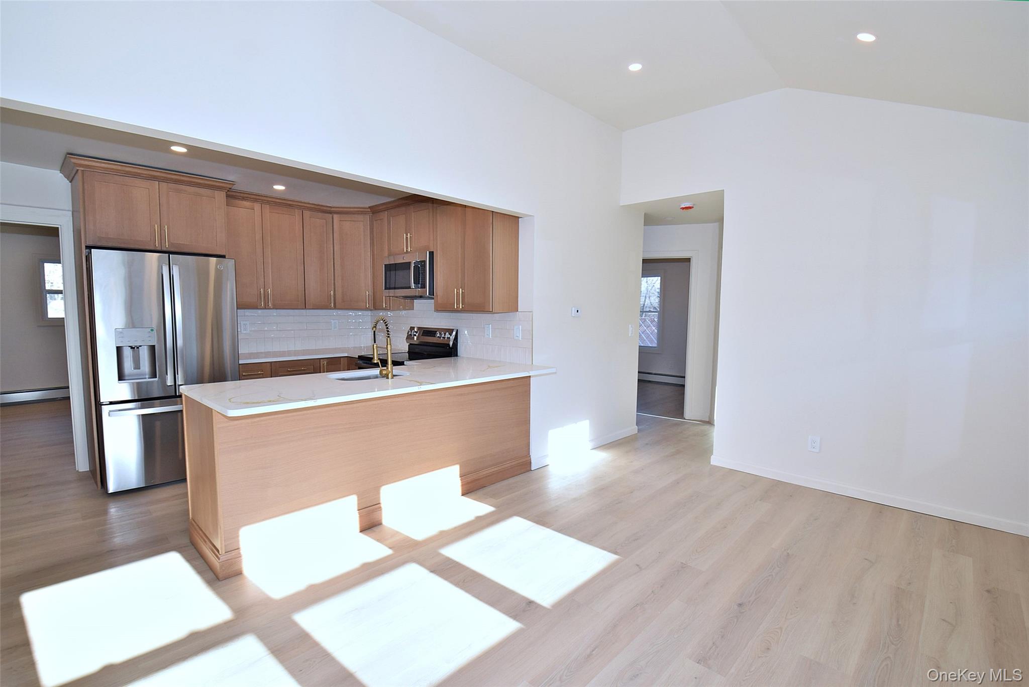 371 Oceanside Street Islip Terrace, NY 11752 - Photo 9 of 38 a kitchen with stainless steel appliances kitchen island granite countertop a refrigerator a stove and a sink with granite countertops