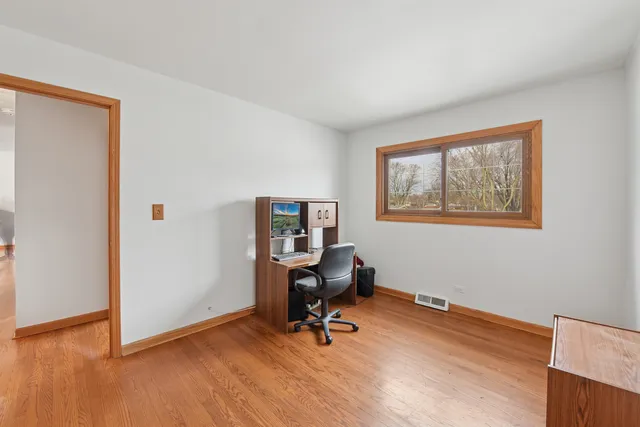 a view of a workspace with furniture and a window