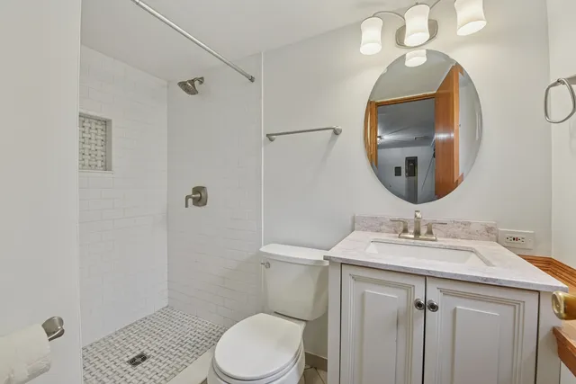 a bathroom with a sink vanity mirror and toilet