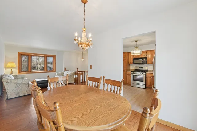 a dining room with furniture a chandelier and wooden floor