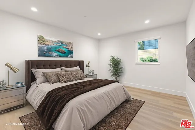 a bedroom with a large bed and a wooden floor