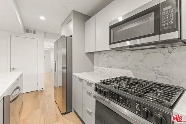 a stove top oven sitting inside of a kitchen