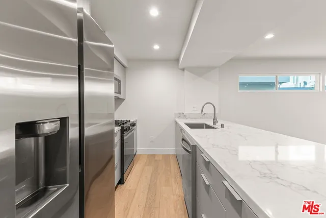 a kitchen with a sink and stainless steel appliances