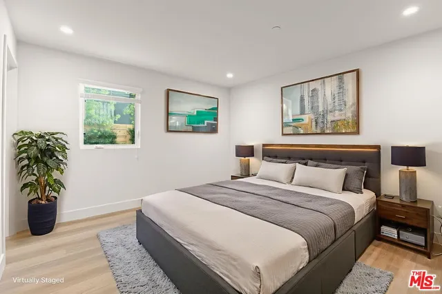 a bedroom with bed and a potted plant