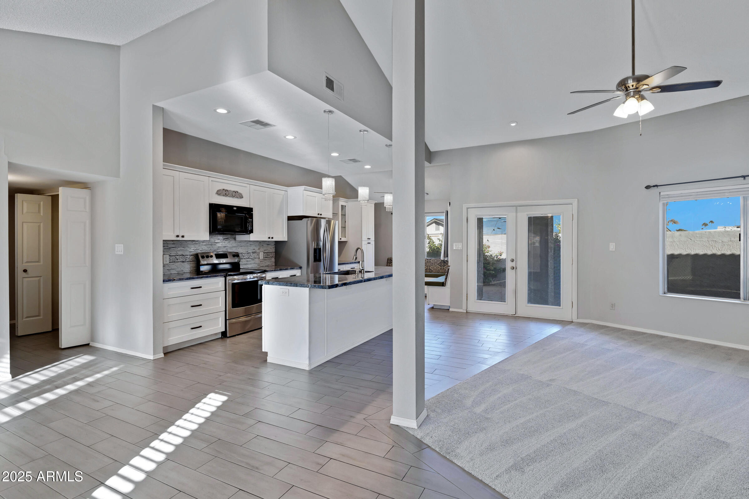 792 West El Monte Place, Unit 8 Chandler, AZ 85225 - Photo 11 of 33 a large white kitchen with kitchen island a sink stainless steel appliances and cabinets