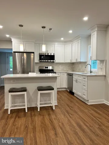 a kitchen with kitchen island granite countertop a stove a sink and a microwave