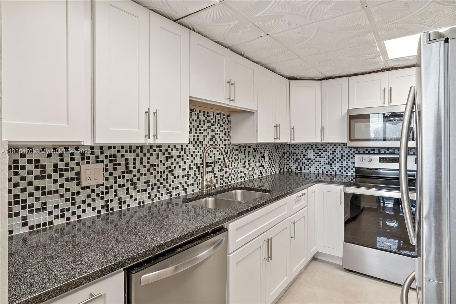 1401 South Federal Highway, Unit 204 Boca Raton, FL 33432 - Photo 3 of 22 a kitchen with granite countertop white cabinets and white appliances