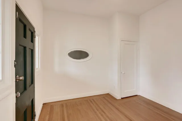 an empty room with wooden floor and closet