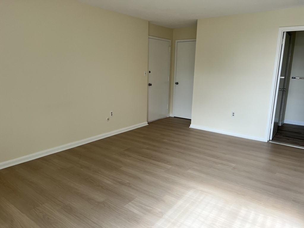 1002 Paradise Road, Unit 1M Swampscott, MA 01907 - Photo 15 of 25 an empty room with wooden floor