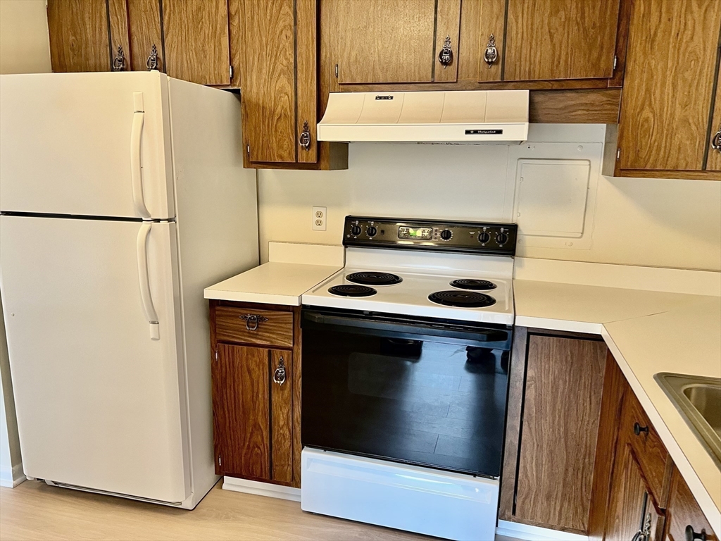 1002 Paradise Road, Unit 1M Swampscott, MA 01907 - Photo 8 of 25 a kitchen with a refrigerator and a stove
