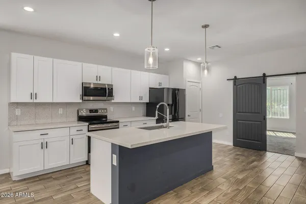 a kitchen with kitchen island a sink appliances and cabinets