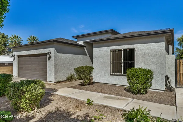 a front view of a house with potted plants