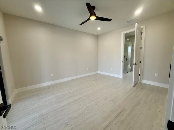 an empty room with wooden floor and a ceiling fan