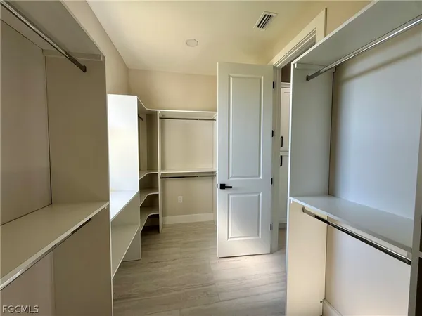 a view of walk in closet with wooden floor